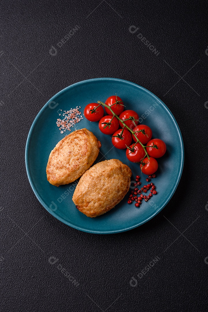 Deliciosas costeletas picadas fritas frescas com especiarias e ervas sobre um fundo escuro de concreto