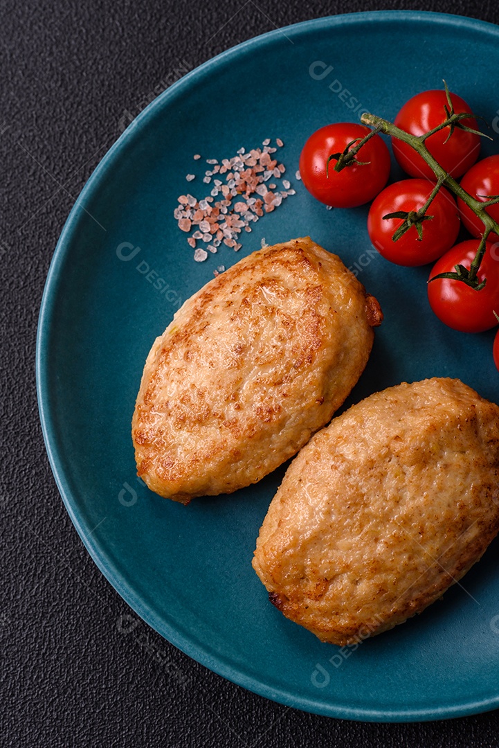 Deliciosas costeletas picadas fritas frescas com especiarias e ervas sobre um fundo escuro de concreto