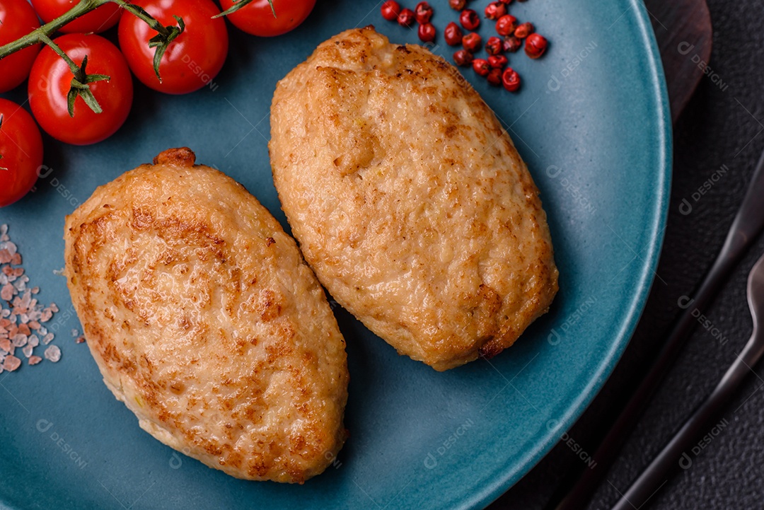 Deliciosas costeletas picadas fritas frescas com especiarias e ervas sobre um fundo escuro de concreto