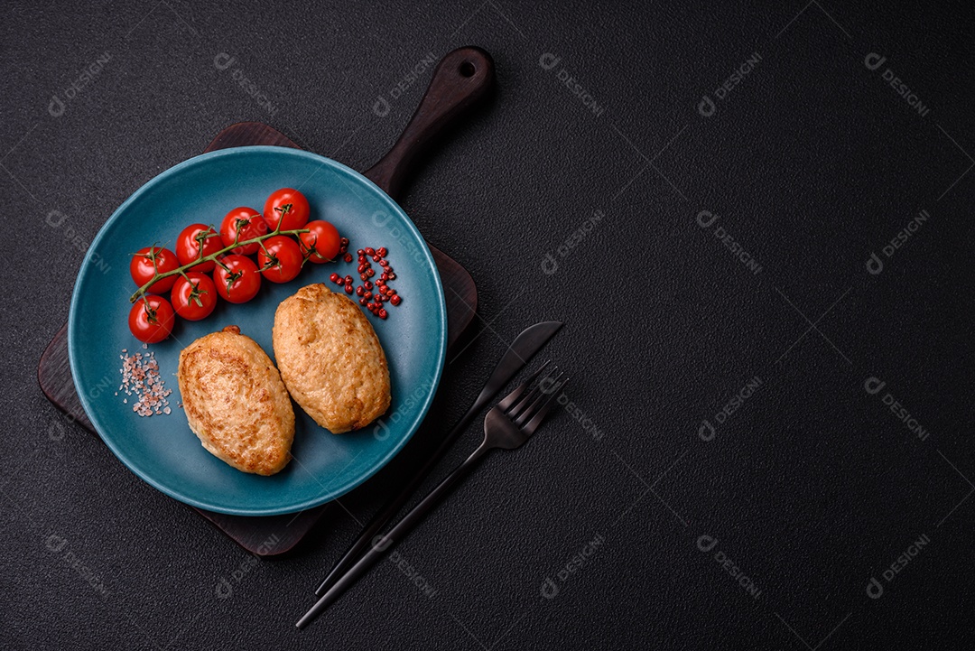 Deliciosas costeletas picadas fritas frescas com especiarias e ervas sobre um fundo escuro de concreto