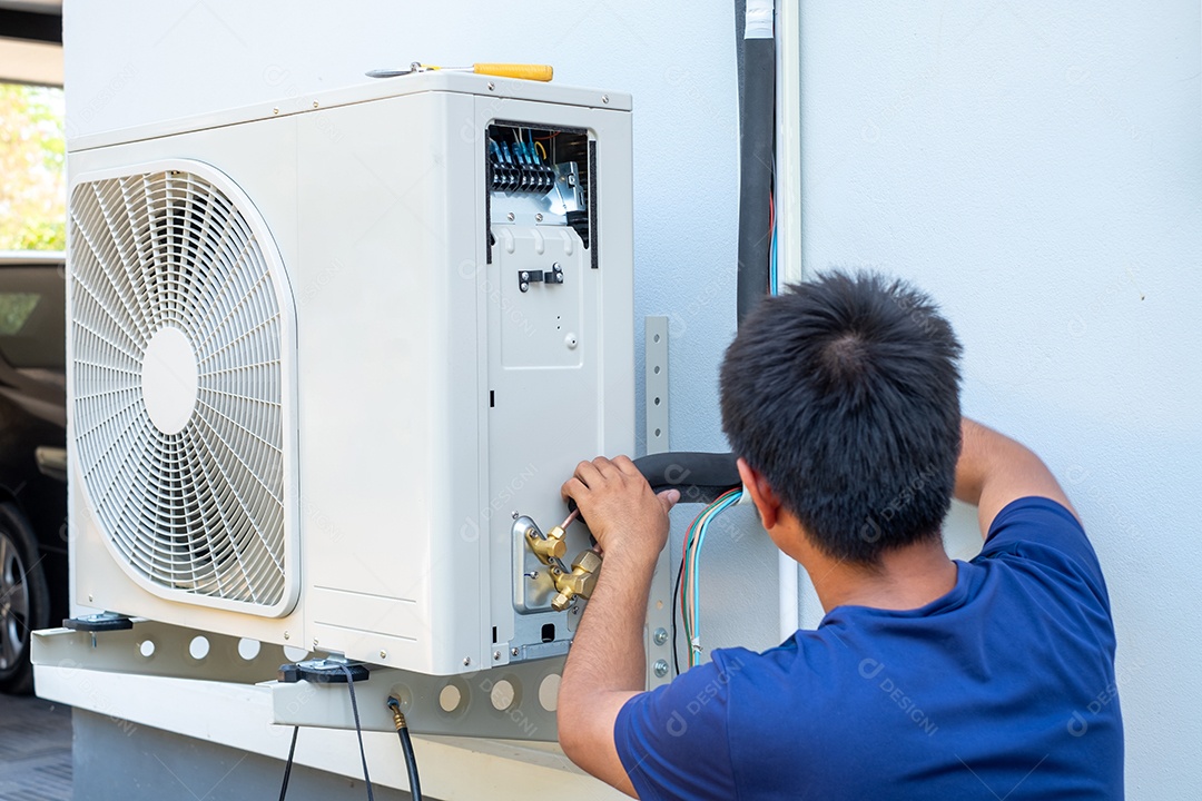 Um homem dando manutenção em ar condicionado