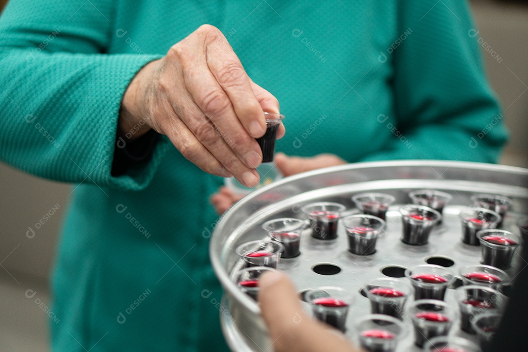 Mão pegando vinho para ceiar na igreja