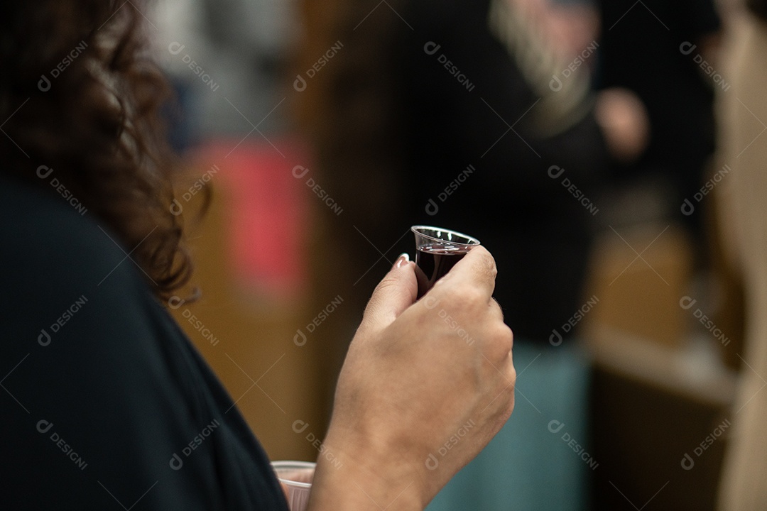 Uma pessoa na igreja segurando vinho da santa ceia