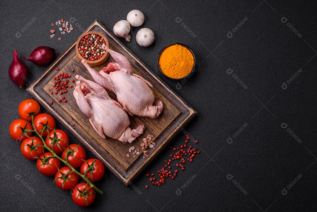 Codornizes cruas inteiras com sal, especiarias e ervas sobre um fundo escuro de concreto preparado para assar