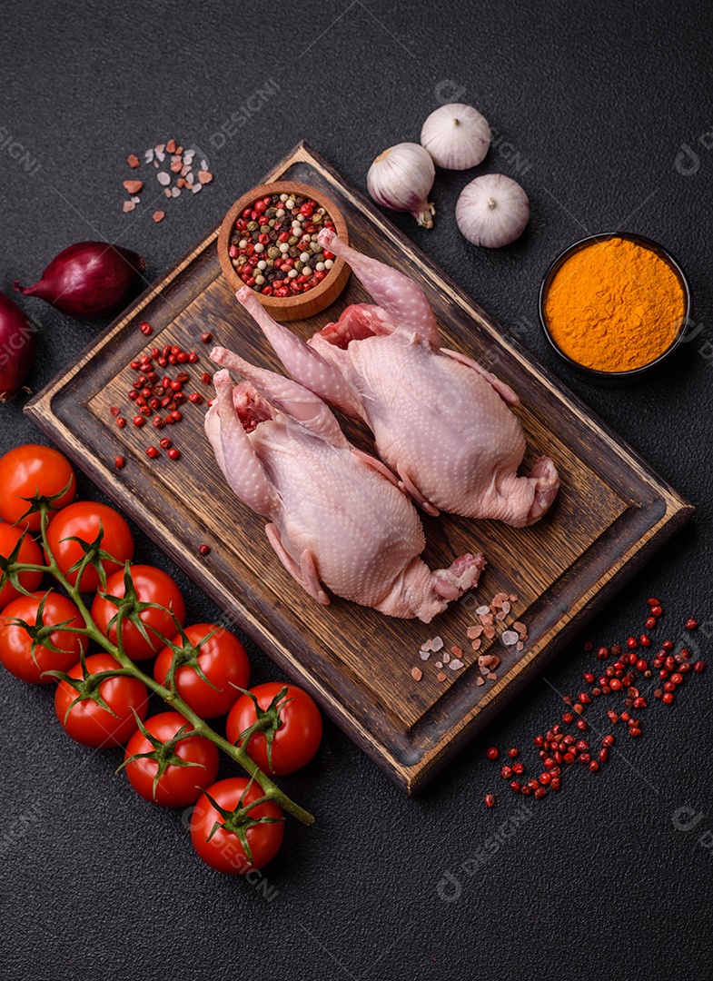 Codornizes cruas inteiras com sal, especiarias e ervas sobre um fundo escuro de concreto preparado para assar