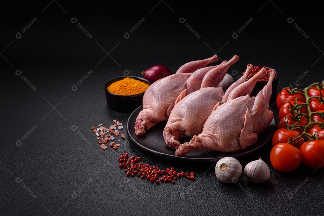 Codornizes cruas inteiras com sal, especiarias e ervas sobre um fundo escuro de concreto preparado para assar