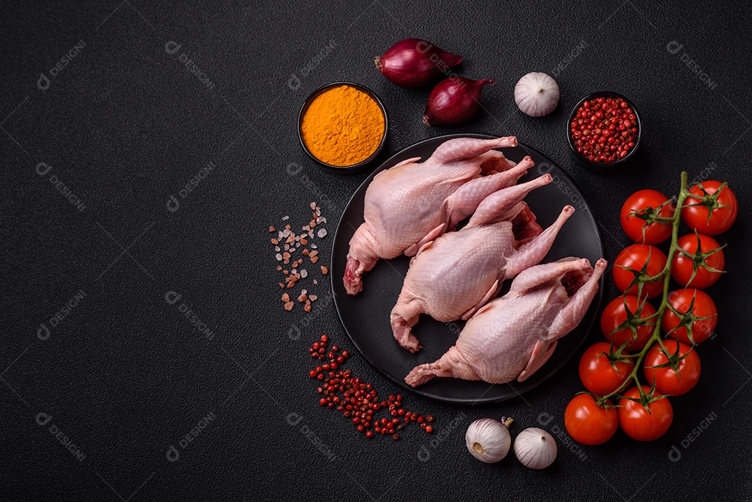 Codornizes cruas inteiras com sal, especiarias e ervas sobre um fundo escuro de concreto preparado para assar