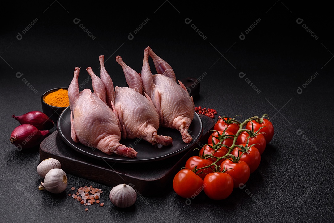 Codornizes cruas inteiras com sal, especiarias e ervas sobre um fundo escuro de concreto preparado para assar