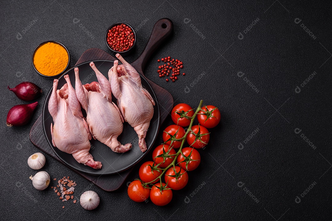 Codornizes cruas inteiras com sal, especiarias e ervas sobre um fundo escuro de concreto preparado para assar