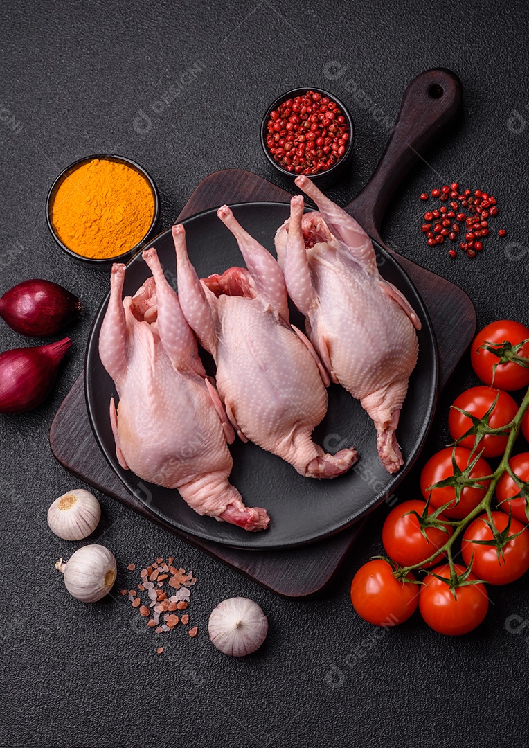 Codornizes cruas inteiras com sal, especiarias e ervas sobre um fundo escuro de concreto preparado para assar