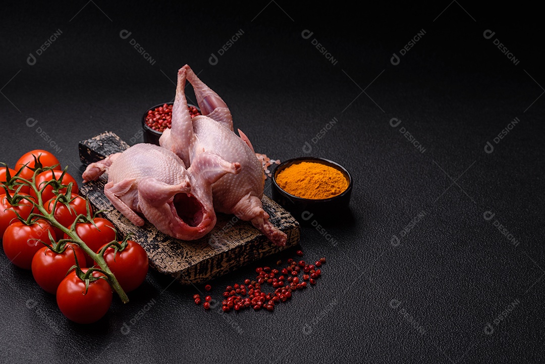 Pernas de frango cru com sal, especiarias e ervas sobre um fundo escuro de concreto preparado para assar