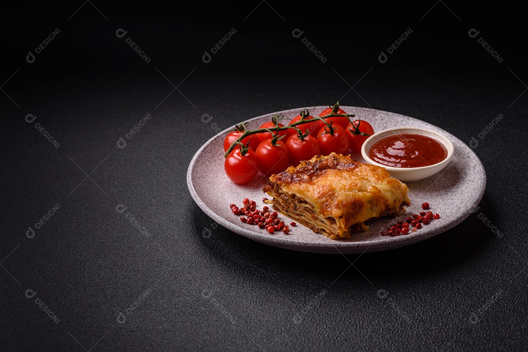 Deliciosa massa de lasanha assada com carne, molho, sal, especiarias e ervas sobre um fundo escuro de concreto