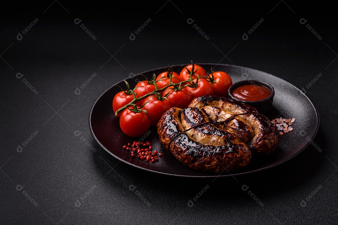 Deliciosa salsicha grelhada em forma de anel com sal, especiarias e ervas sobre fundo escuro de concreto