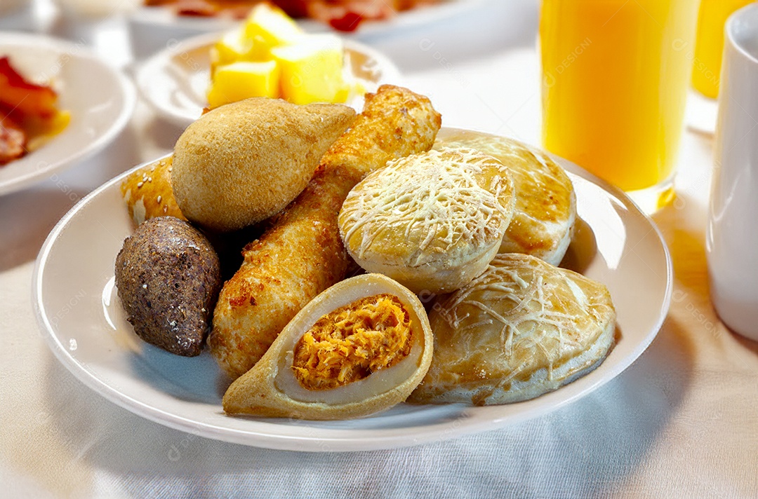 Salgadinhos brasileiros assados e fritos em um prato branco