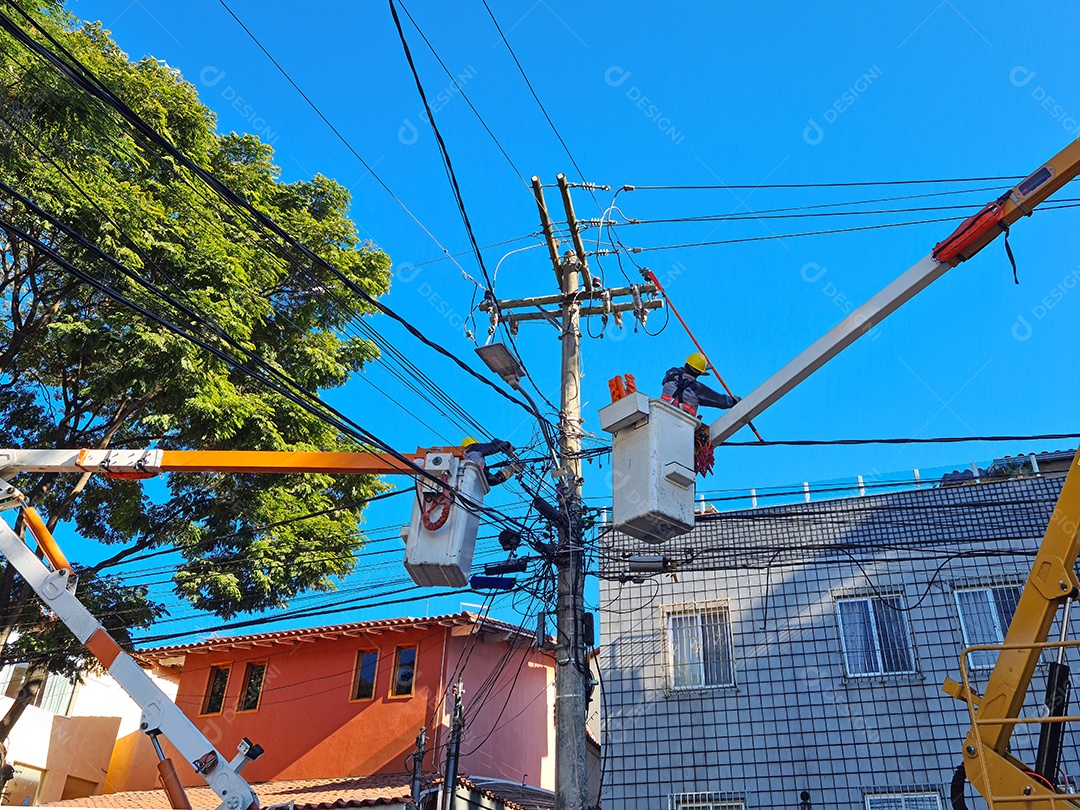 Trabalhadores no guindaste realizando manutenção na rede elétrica