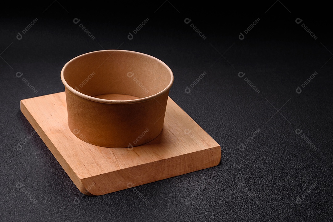 Placa redonda de cerâmica vazia em fundo de concreto texturizado escuro. Talheres, preparação para o jantar