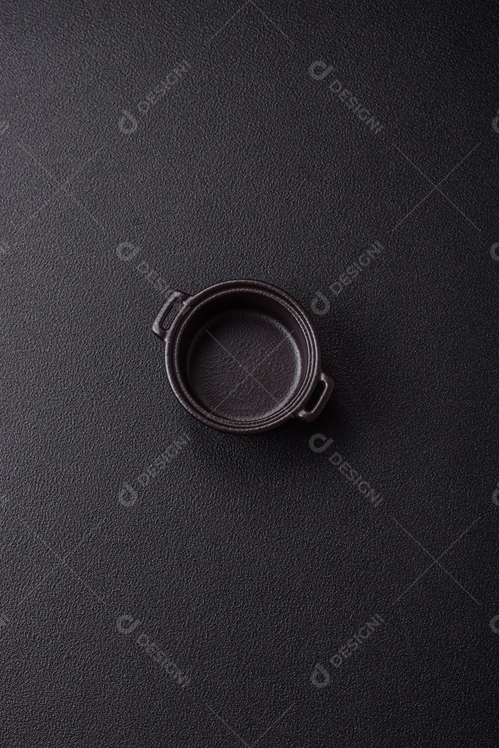 Placa redonda de cerâmica vazia em fundo de concreto texturizado escuro. Talheres, preparação para o jantar