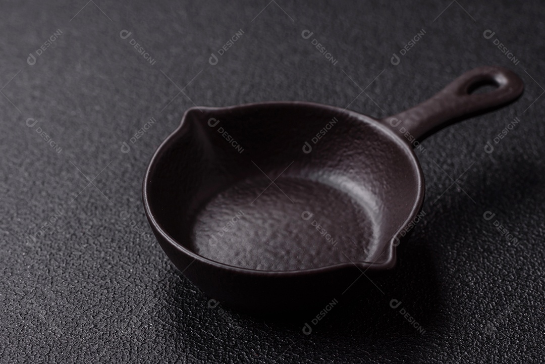 Placa redonda de cerâmica vazia em fundo de concreto texturizado escuro. Talheres, preparação para o jantar