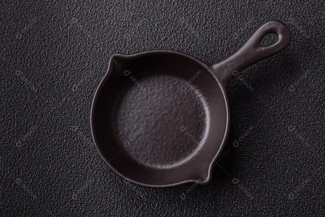 Placa redonda de cerâmica vazia em fundo de concreto texturizado escuro. Talheres, preparação para o jantar