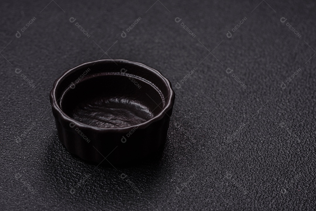 Placa redonda de cerâmica vazia em fundo de concreto texturizado escuro. Talheres, preparação para o jantar