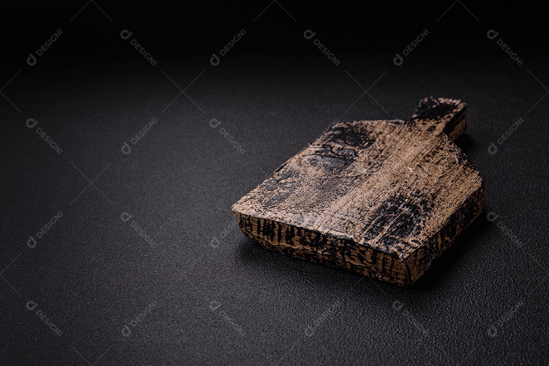 Tábua de corte de madeira vazia em fundo de concreto texturizado escuro. Talheres, preparação para o jantar