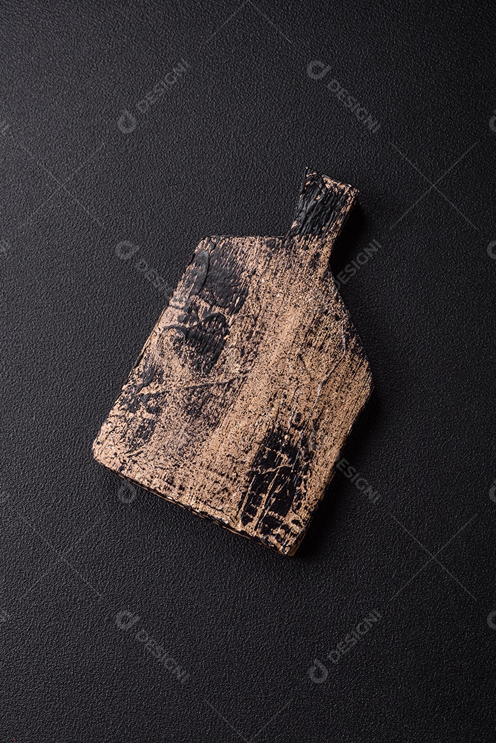 Tábua de corte de madeira vazia em fundo de concreto texturizado escuro. Talheres, preparação para o jantar