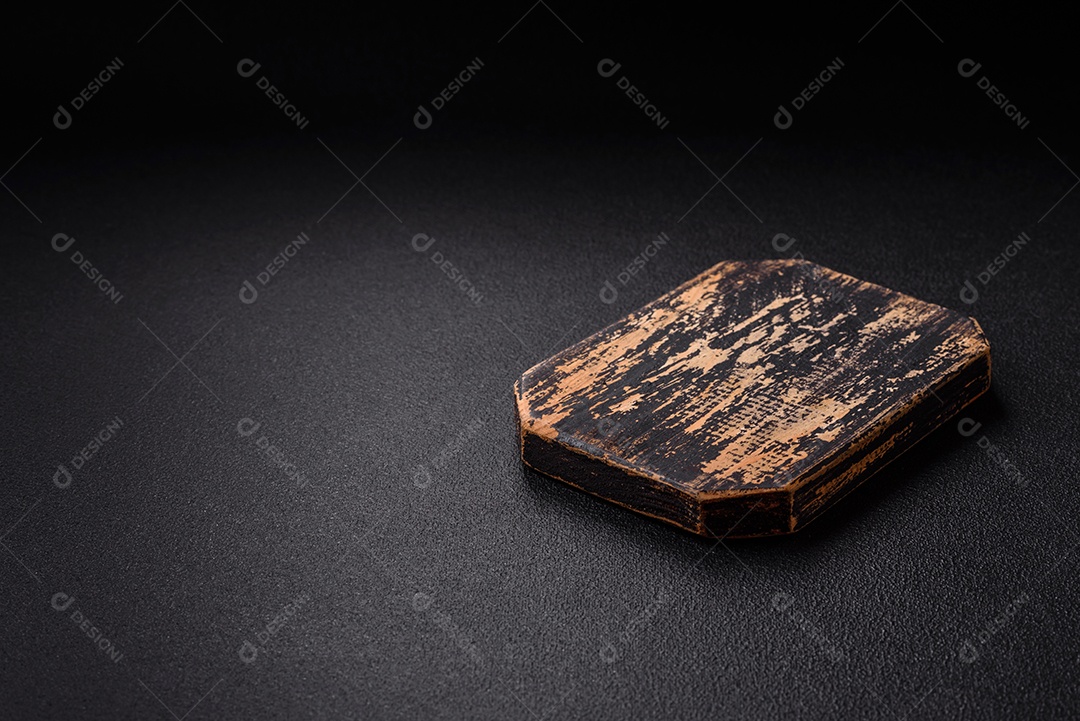 Tábua de corte de madeira vazia em fundo de concreto texturizado escuro. Talheres, preparação para o jantar