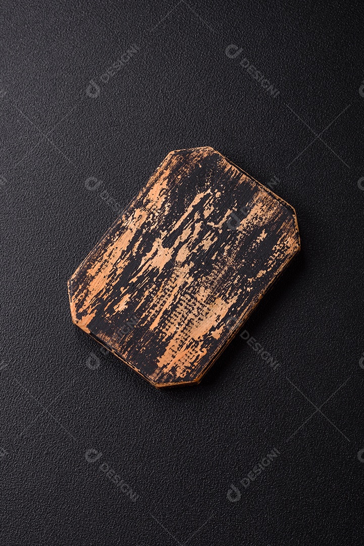 Tábua de corte de madeira vazia em fundo de concreto texturizado escuro. Talheres, preparação para o jantar