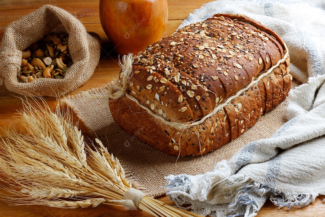 Pão integral com grãos fatiados isoladas em fundo mesa de madeira