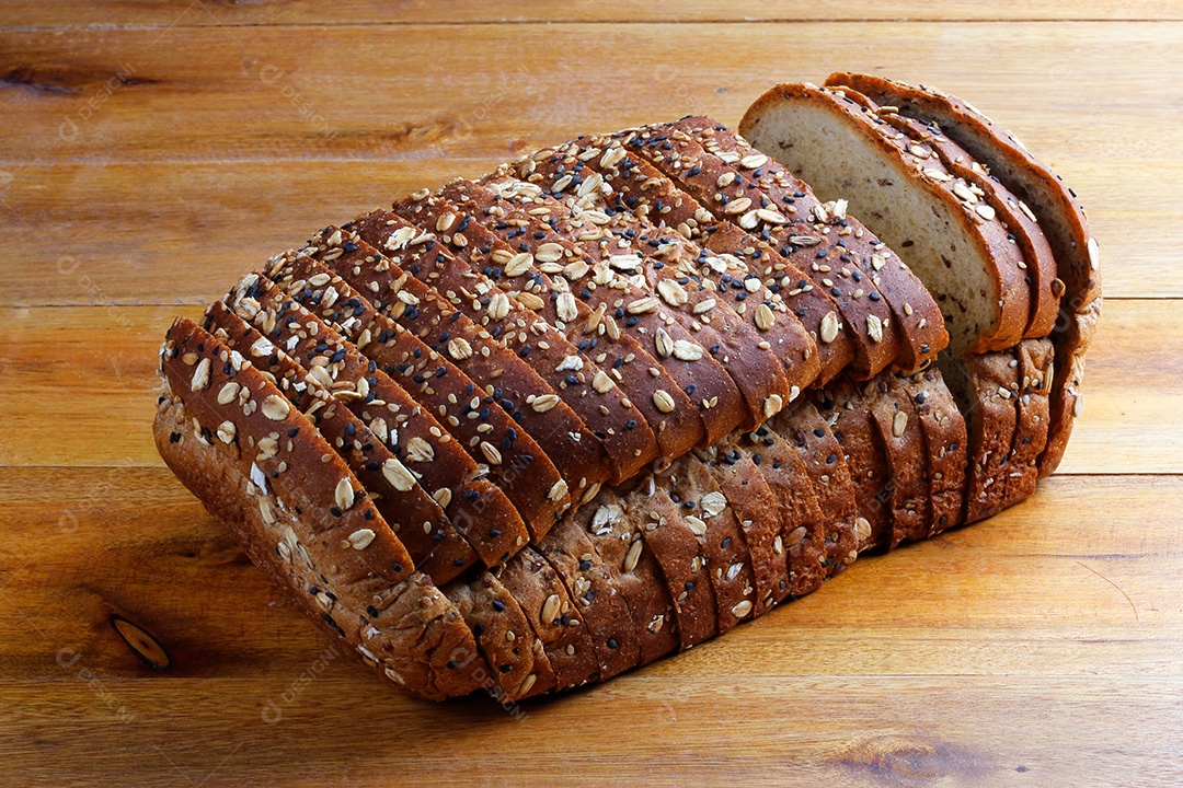 Pão integral com grãos fatiados isoladas em fundo de madeira