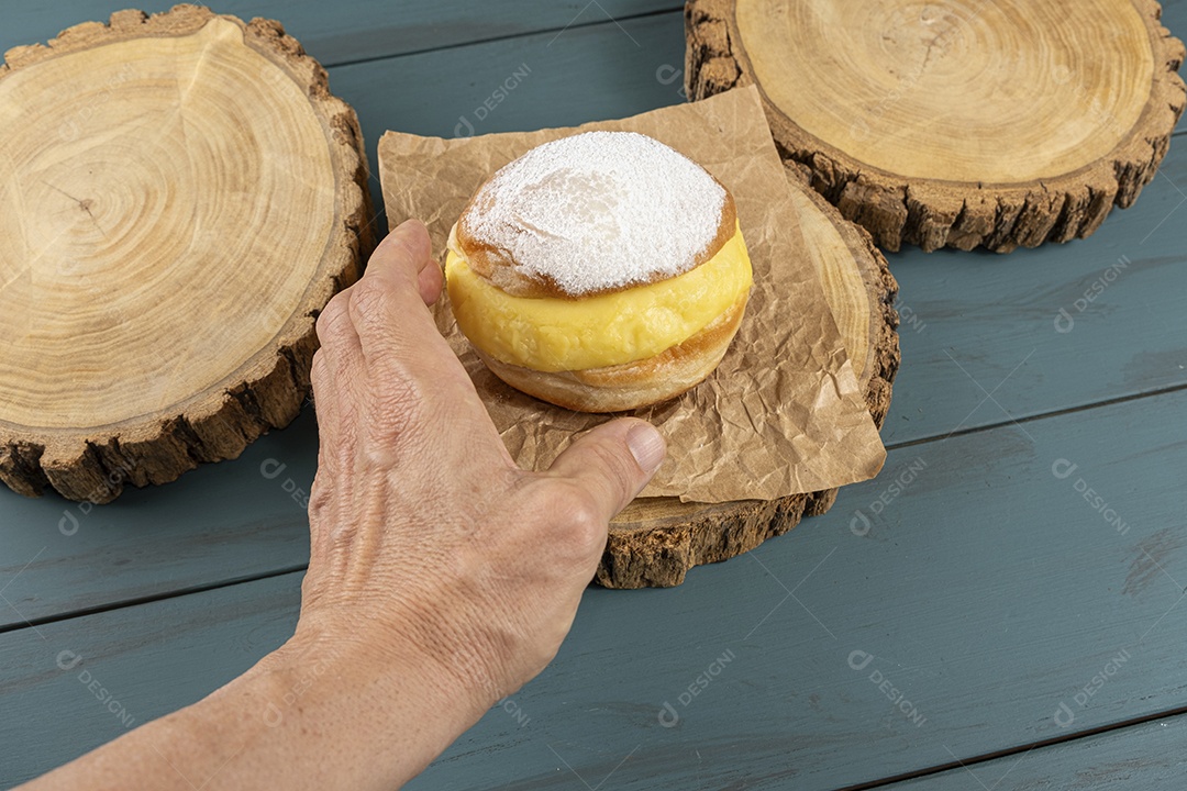 Mão pegando doce sonho sobre tábua de madeira