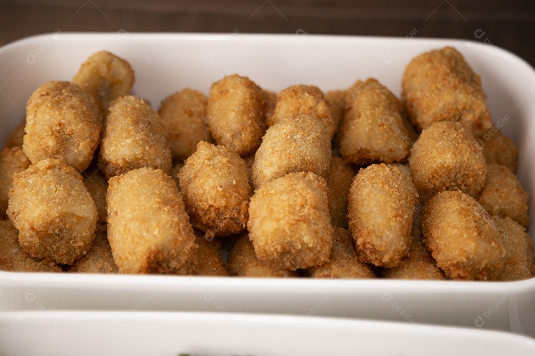 Bolinhos fritos sobre tigela mesa de madeira branca