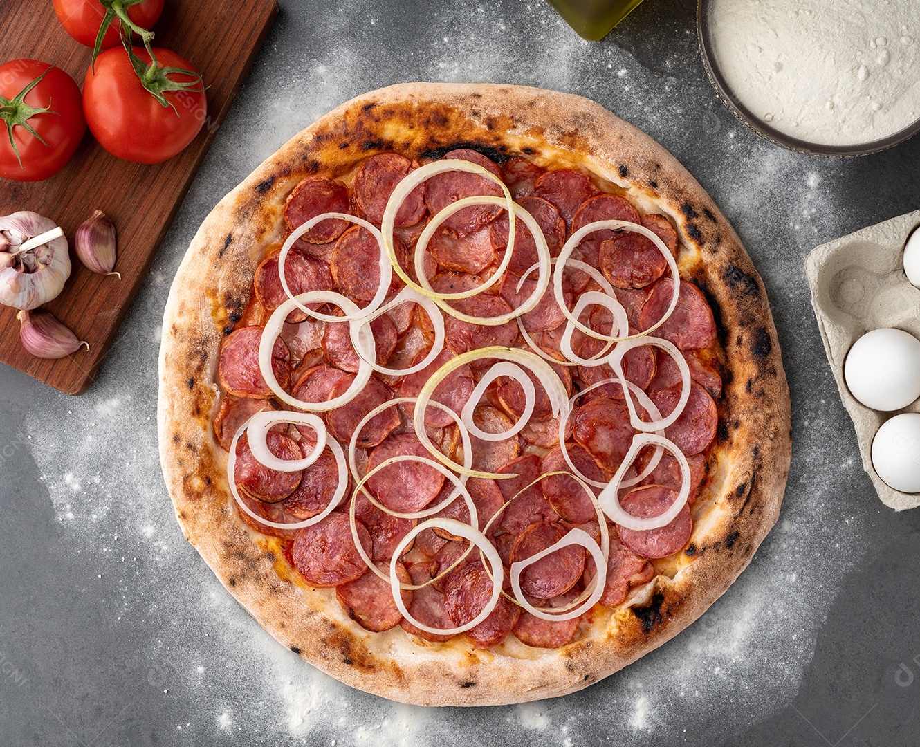 Pizza de calabresa acebolada em uma mesa de pedra
