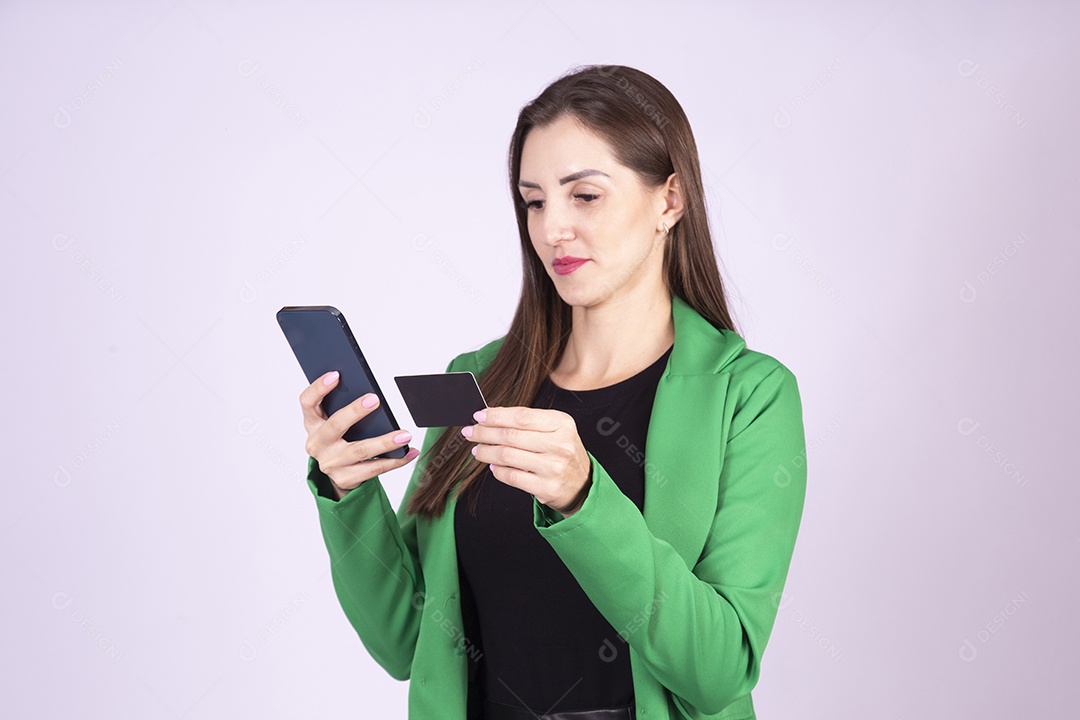 Linda mulher jovem sobre fundo isolado segurando cartão de crédito e smartphone