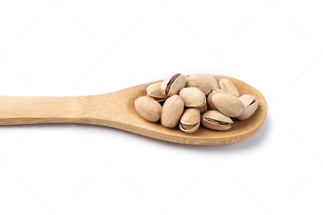 Pistácios torrados salgados em uma colher isolados sobre fundo branco