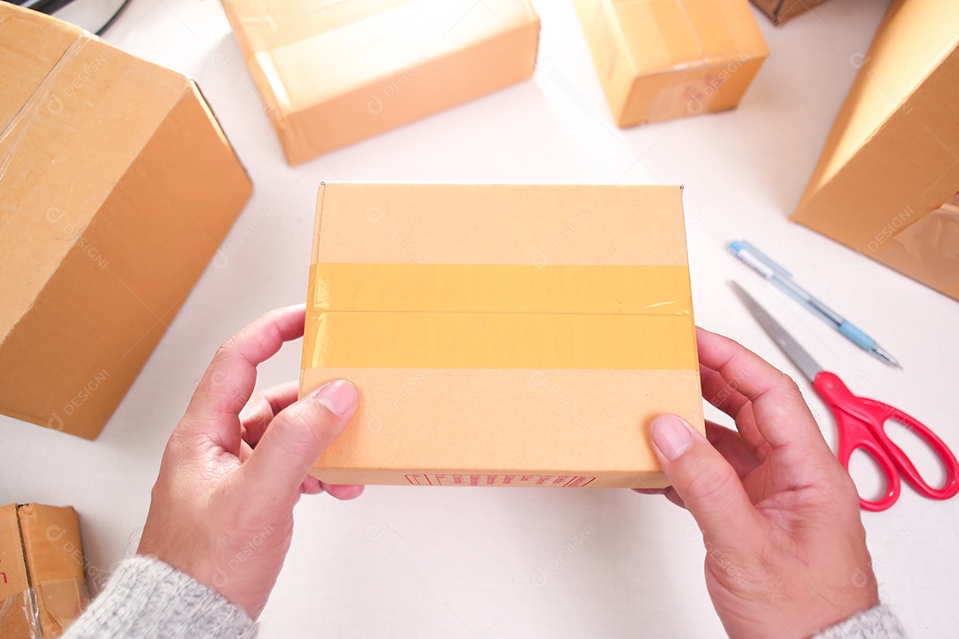Mãos segurando caixa para embalar
