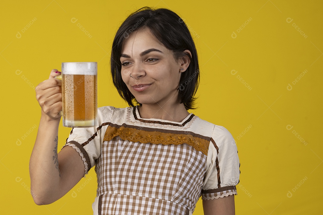 Jovem vestindo fantasia típica de festa junina segurando uma caneca de cerveja gelada
