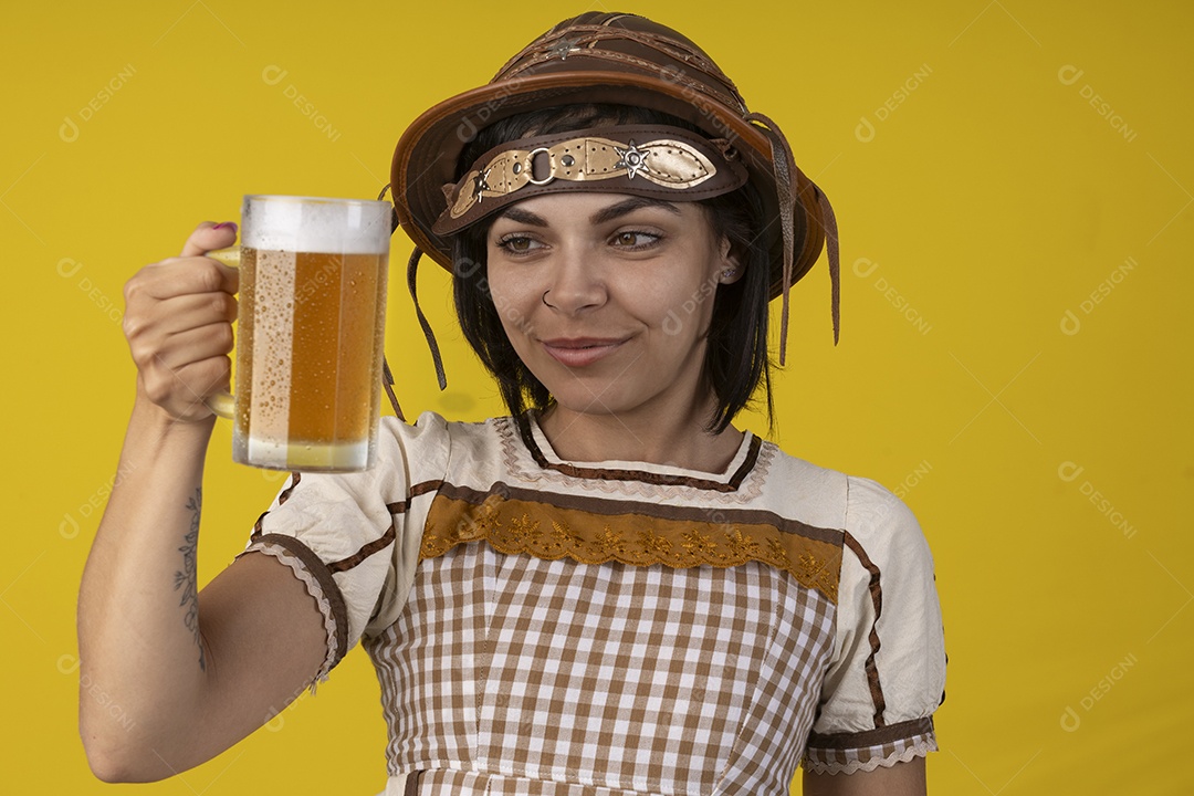 Jovem vestindo fantasia típica de festa junina segurando uma caneca de cerveja gelada
