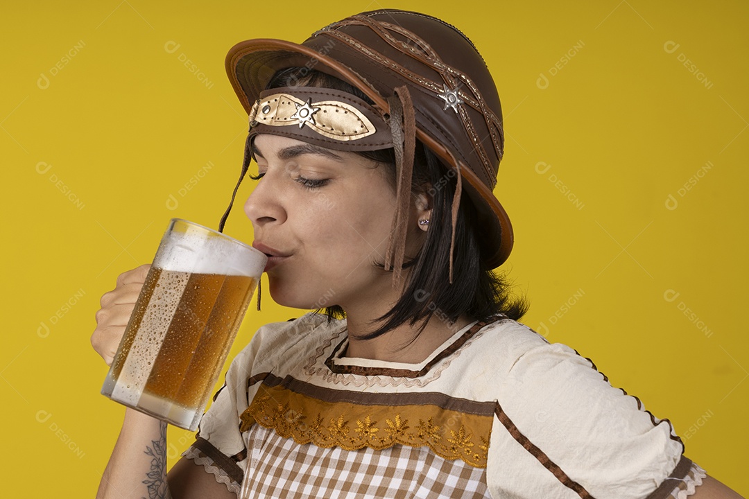 Jovem vestindo fantasia típica de festa junina bebendo uma caneca de cerveja gelada