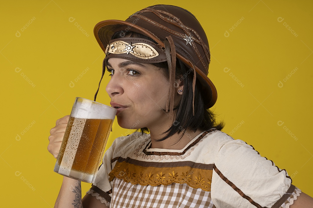 Jovem vestindo fantasia típica de festa junina bebendo uma caneca de cerveja gelada