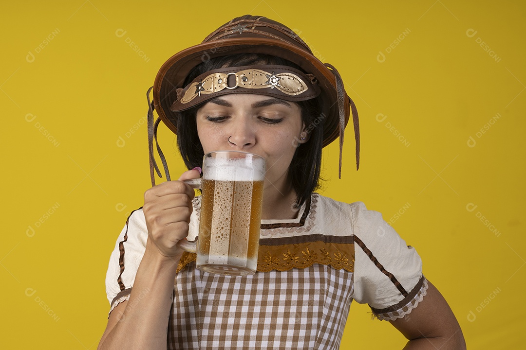 Jovem vestindo fantasia típica de festa junina bebendo uma caneca de cerveja gelada