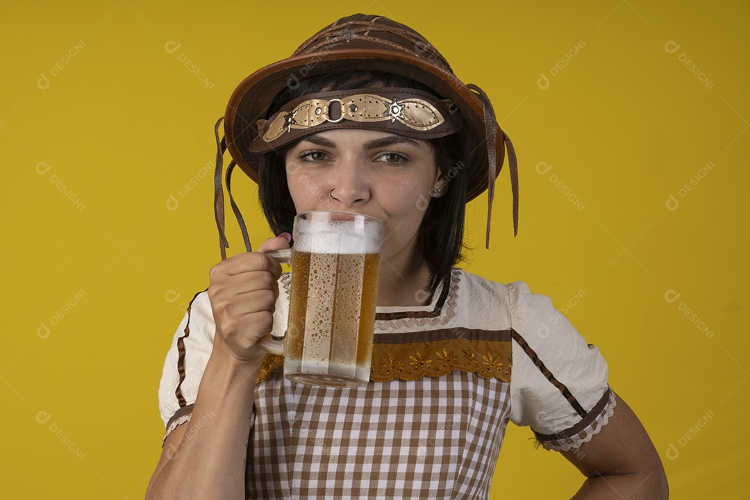 Jovem vestindo fantasia típica de festa junina segurando uma caneca de cerveja gelada