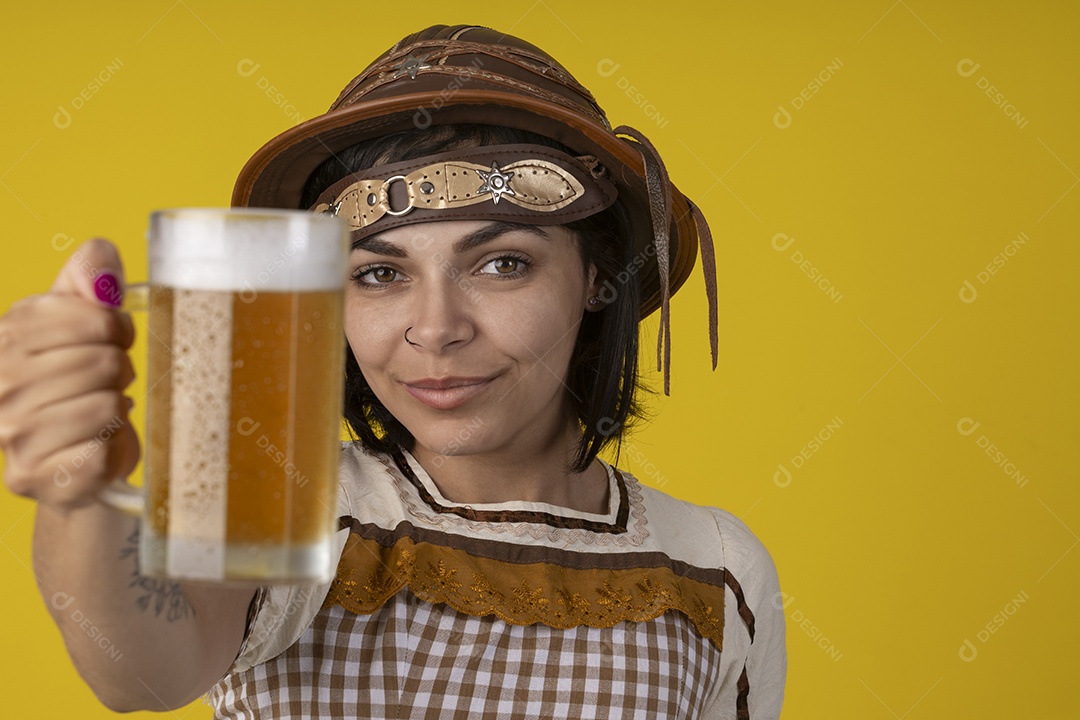 Jovem vestindo fantasia típica de festa junina segurando uma caneca de cerveja gelada
