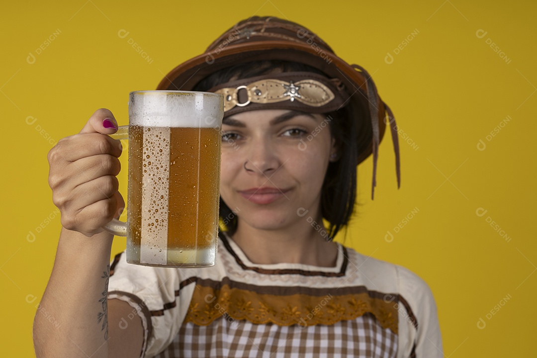 Jovem vestindo fantasia típica de festa junina segurando uma caneca de cerveja gelada