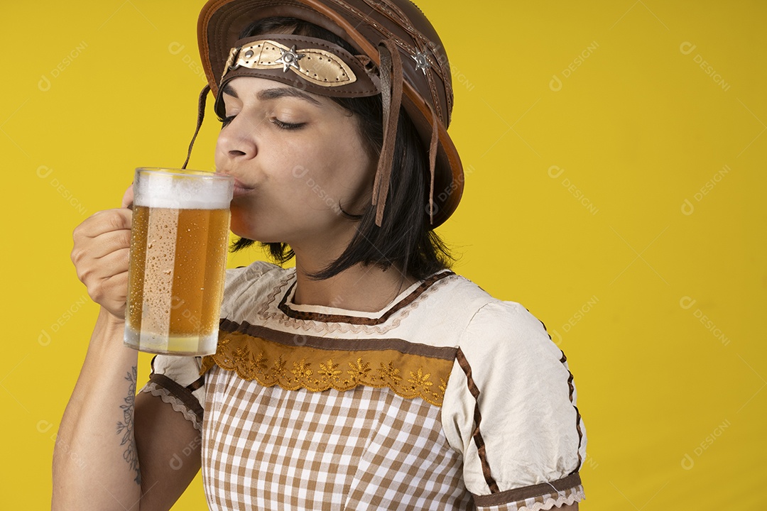 Jovem vestindo fantasia típica de festa junina bebendo uma caneca de cerveja gelada