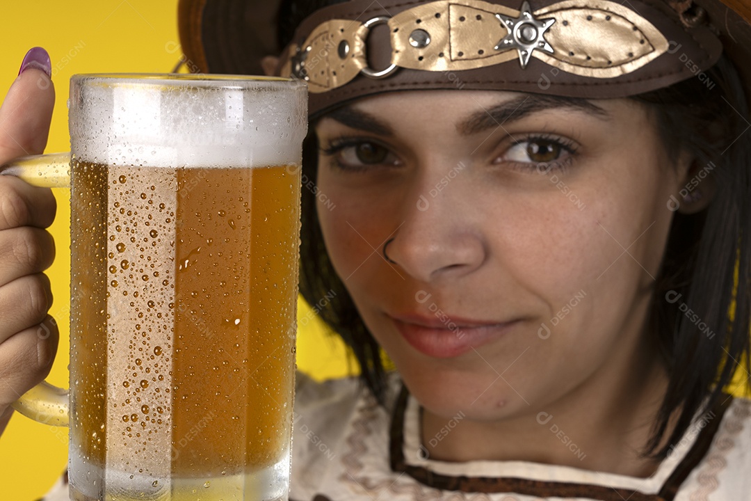 Jovem vestindo fantasia típica de festa junina segurando uma caneca de cerveja gelada