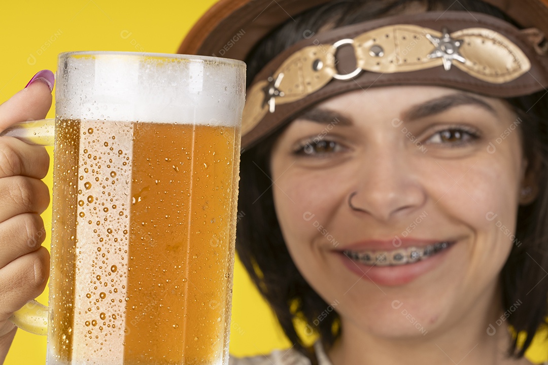Jovem vestindo fantasia típica de festa junina segurando uma caneca de cerveja gelada