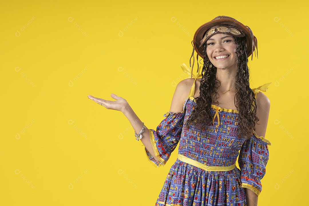 Jovem sorrindo usando chapéu de couro e trajes típico de festa junina