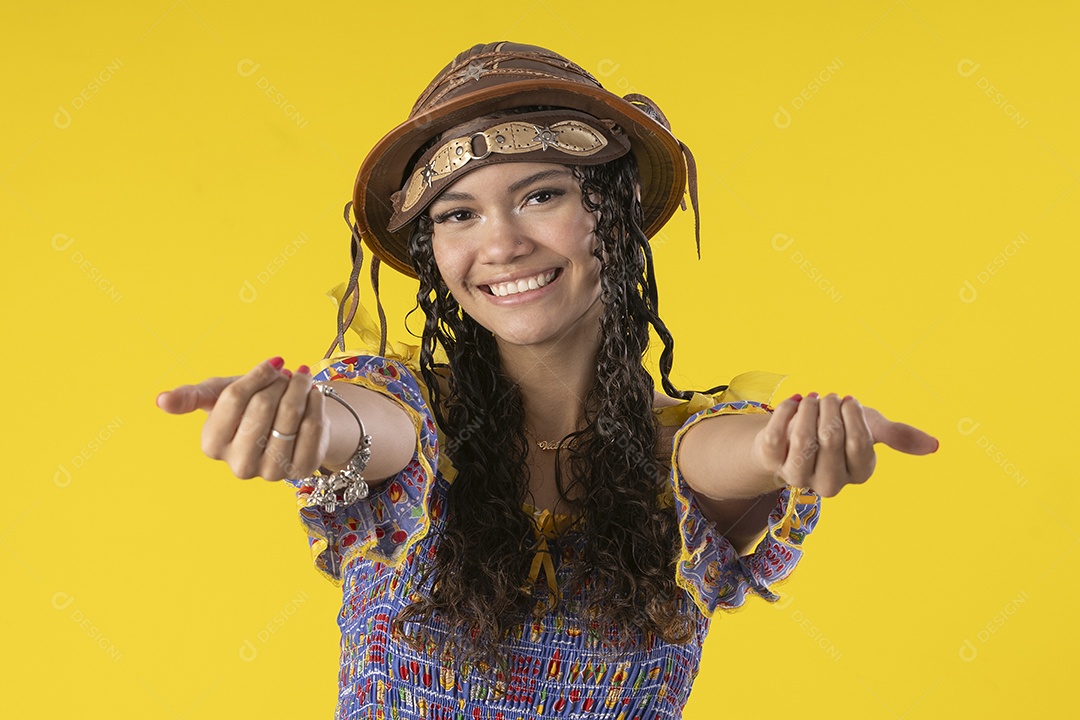 Jovem sorrindo usando chapéu de couro típico de festa junina e chamando