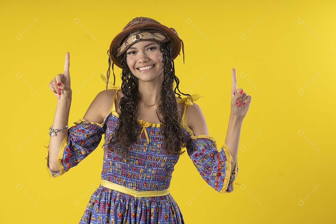 Jovem sorrindo usando chapéu de couro típico de festa junina com dedo pra cima